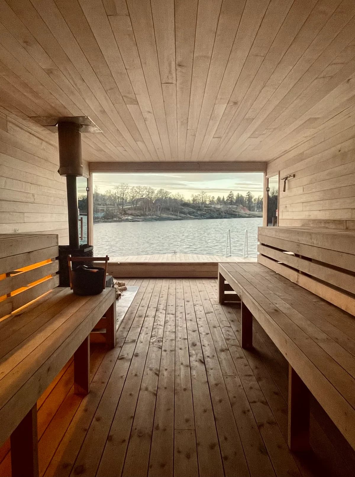 Interiør i BookSauna Thor i Stavanger med trebenker, vedovn og panoramautsikt mot fjorden