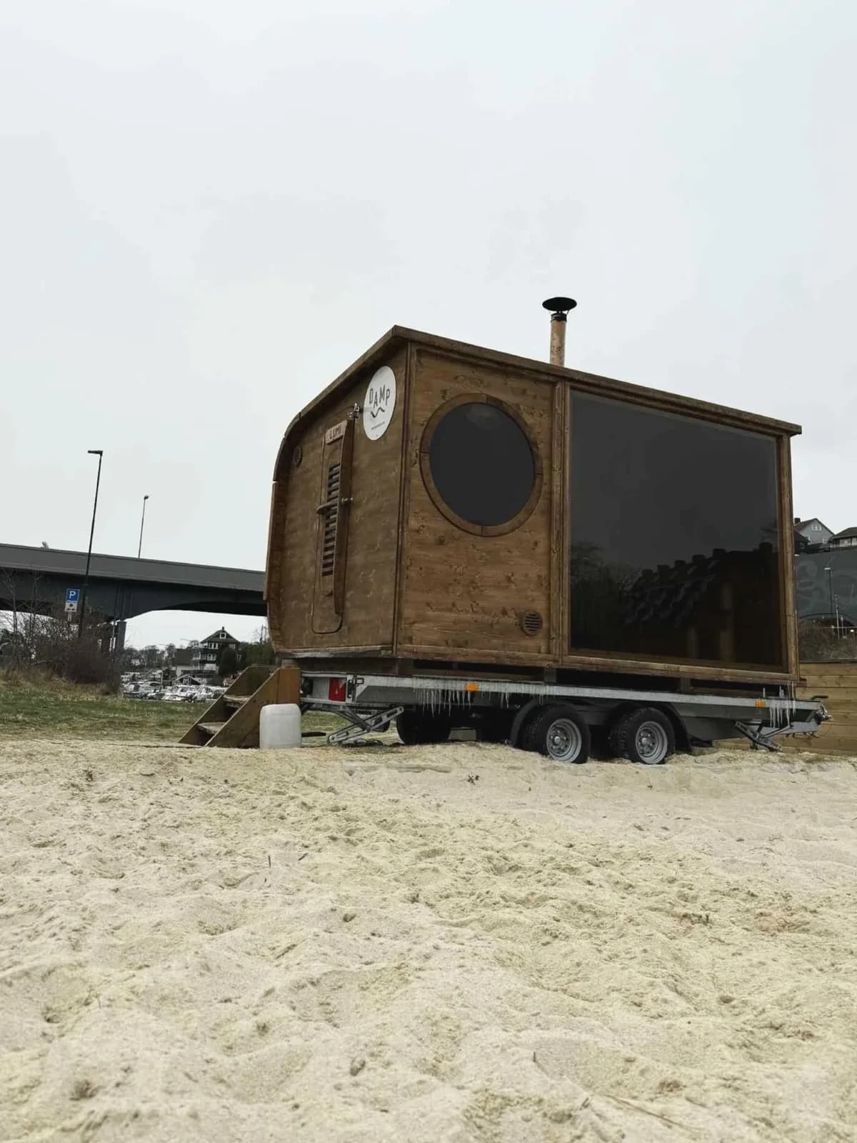 Damp Lumi badstue på tilhenger ved Strømsbrua i Stavanger, trebygg med rundt vindu