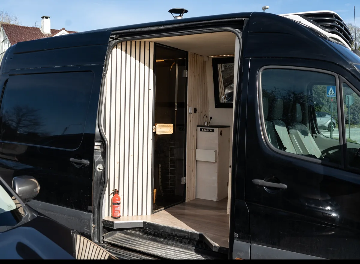 Damp Senja mobil badstue i Stavanger, svart van med åpen sidedør og treinteriør