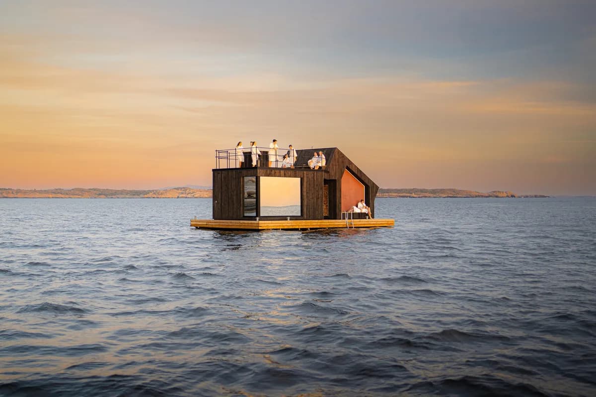 Flytende badstubåt fra Havblikk Fjordsauna på fjorden ved solnedgang i Steinsland