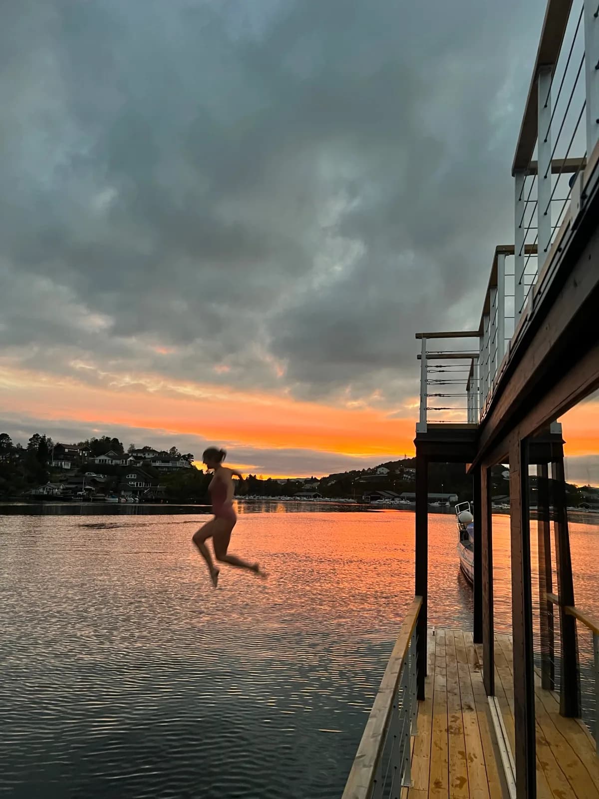 Fagernes Flytebad ved solnedgang Person hopper i vannet fra Fagernes Flytebad ved solnedgang i Straumsgrend