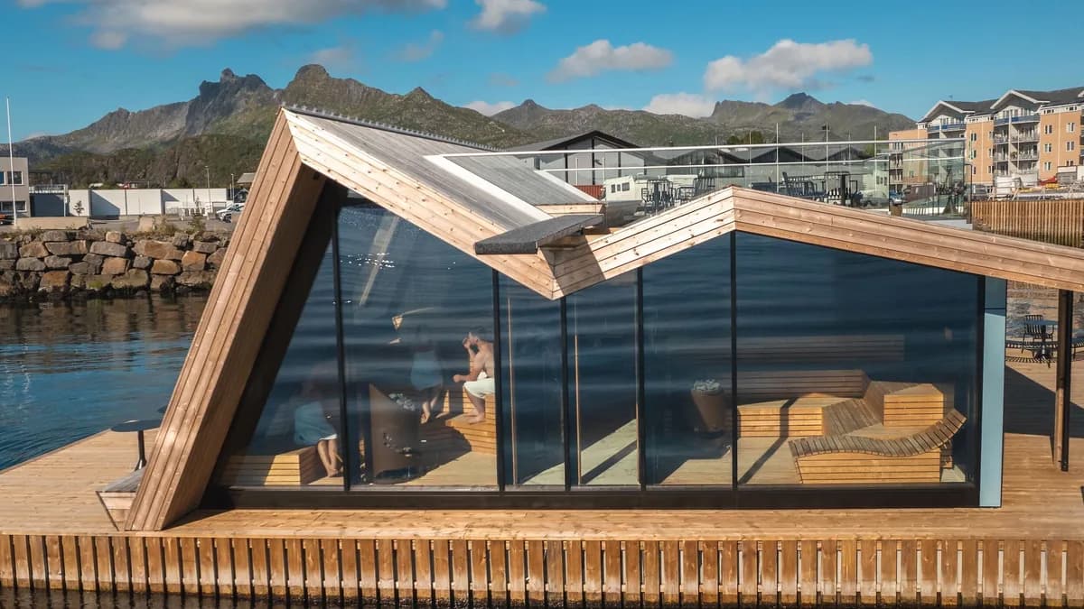 Flytende badstue Lyst Lofoten i Svolvær havn med glassfasade og fjell i bakgrunnen