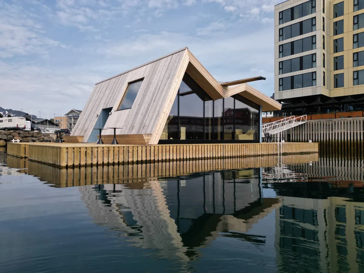 LYST Lofoten Sauna sett fra sjøsiden i Svolvær med Thon Hotel i bakgrunnen
