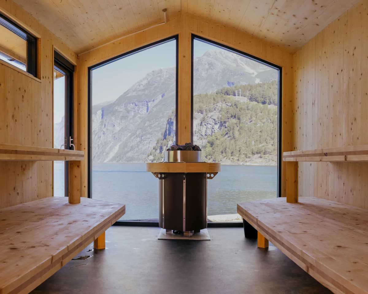 Interiør i Tafjord Sauna med trebenker, elektrisk ovn og panoramautsikt over Tafjorden