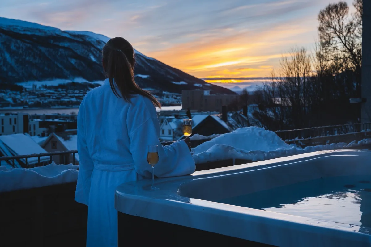 Jacuzzi med utsikt ved St. Elisabeth Spa Utendørs jacuzzi med solnedgang over Tromsø ved St. Elisabeth Spa & Wellness