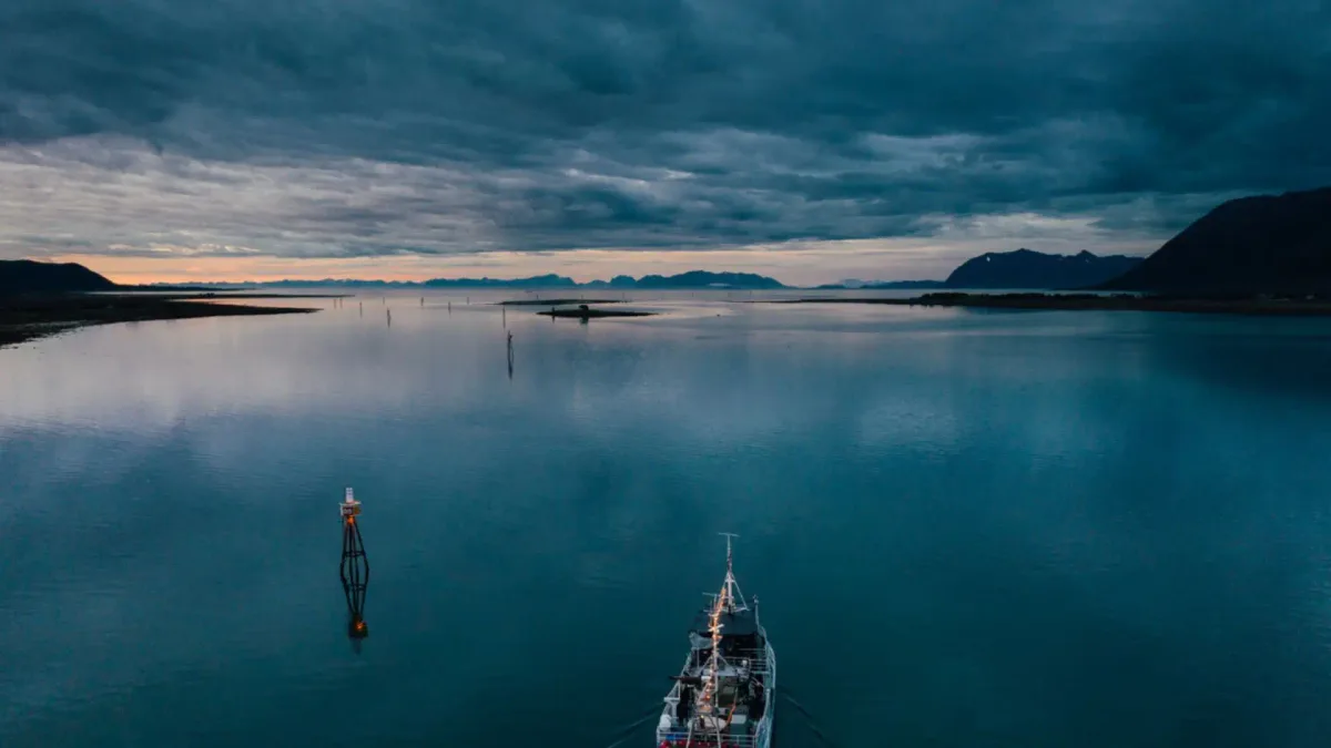 MS Vulkana spa-båt på fjorden i Tromsø med fjell og dramatisk himmel i bakgrunnen