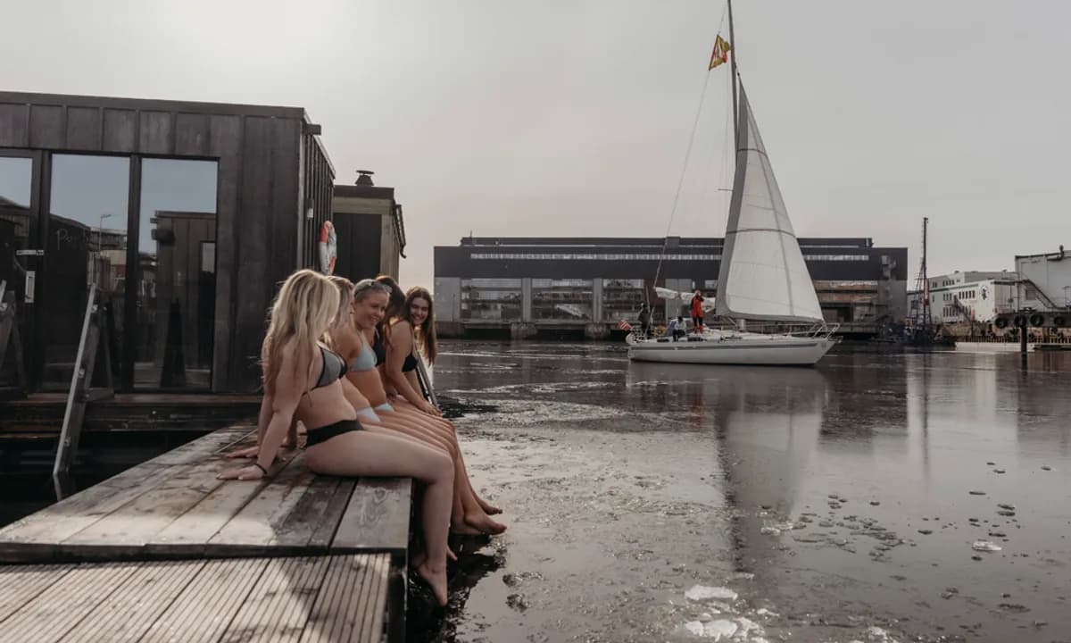 Gjester på brygga ved Havet Sauna i Trondheim med seilbåt i bakgrunnen