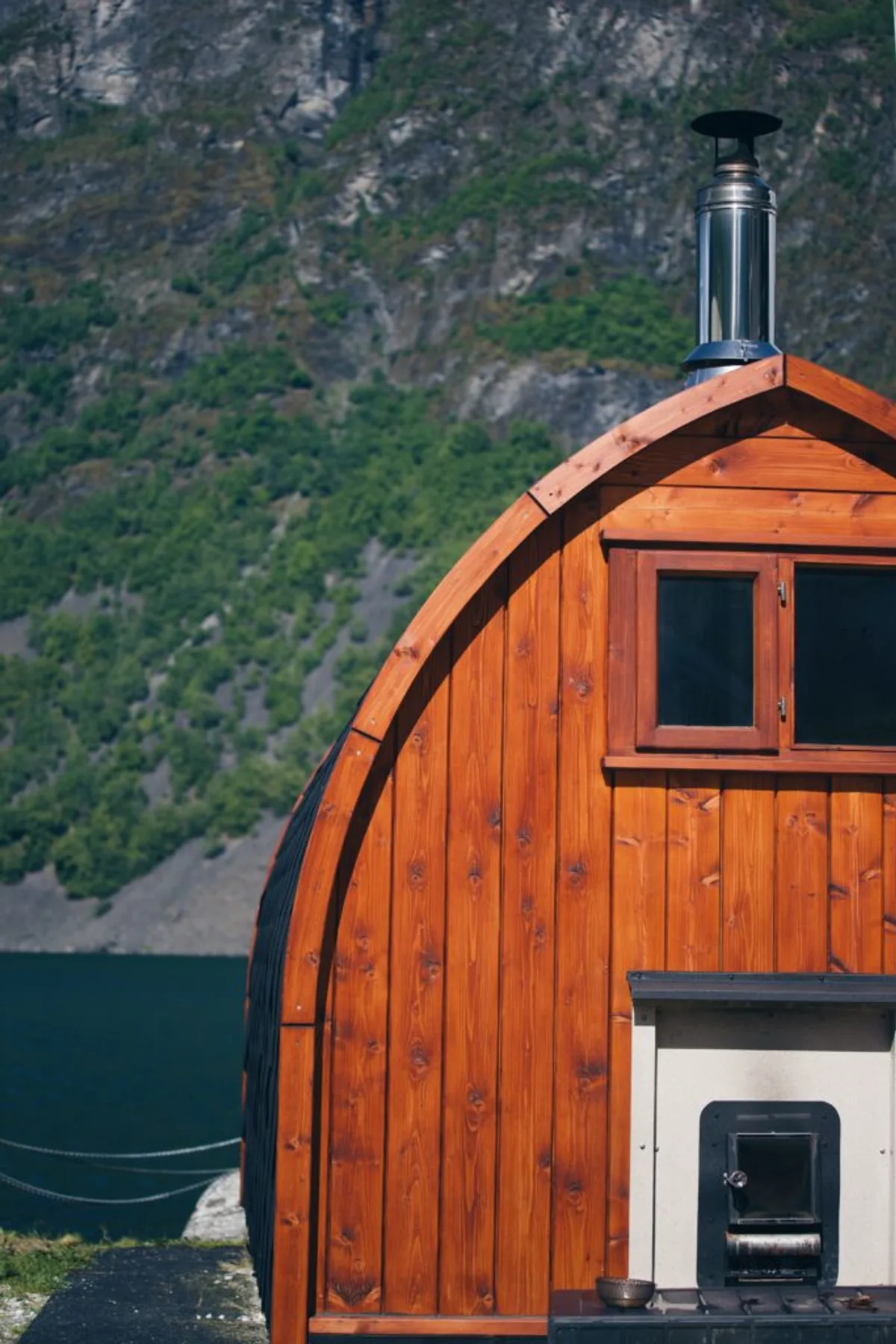 Vedfyrt tønnebastu ved Undredal Sauna med fjord og fjell i bakgrunnen