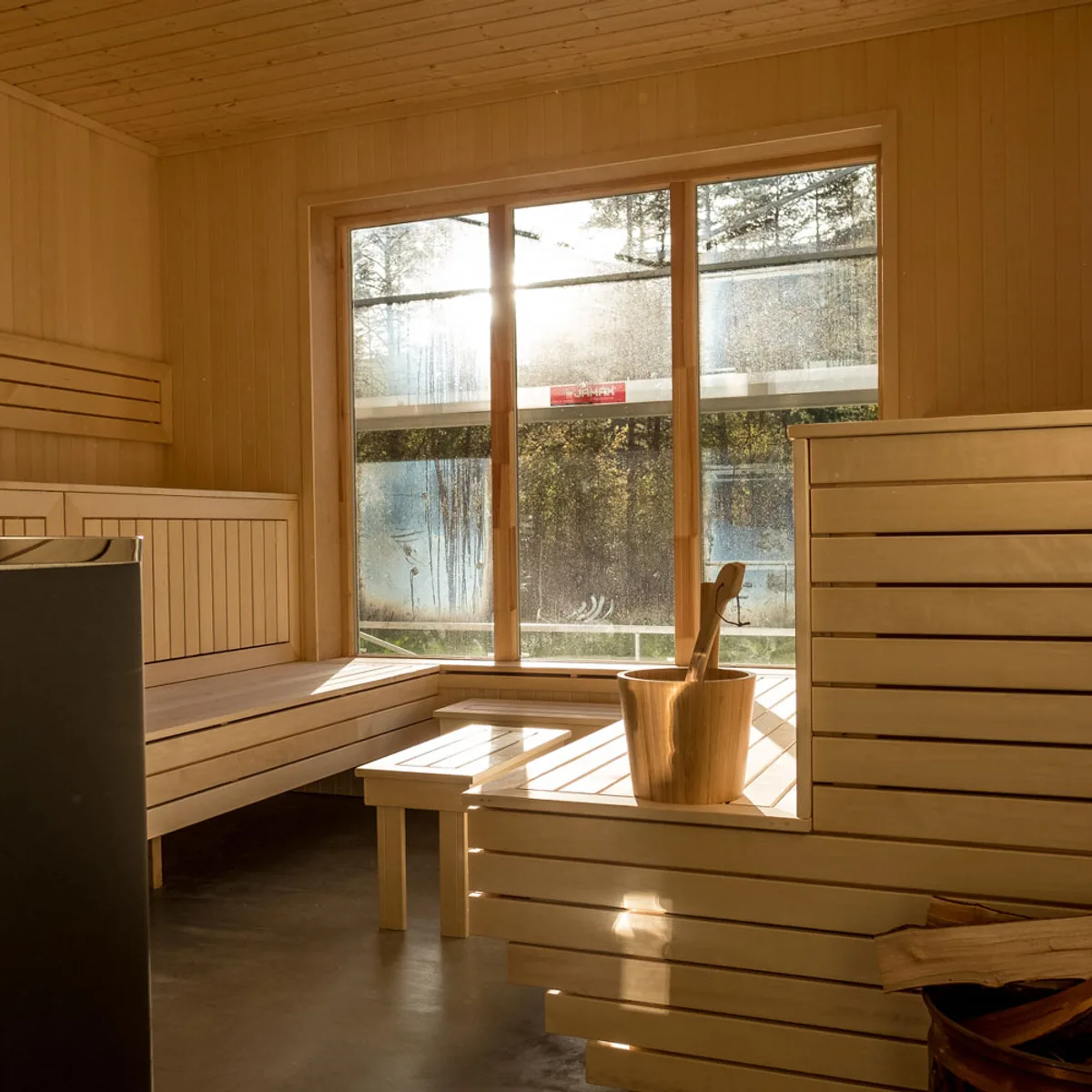 Badstue-interiør hos Meretes Garden Interiør av badstuen i Meretes Garden i Valldal med trebenker, stort vindu og badstubøtte