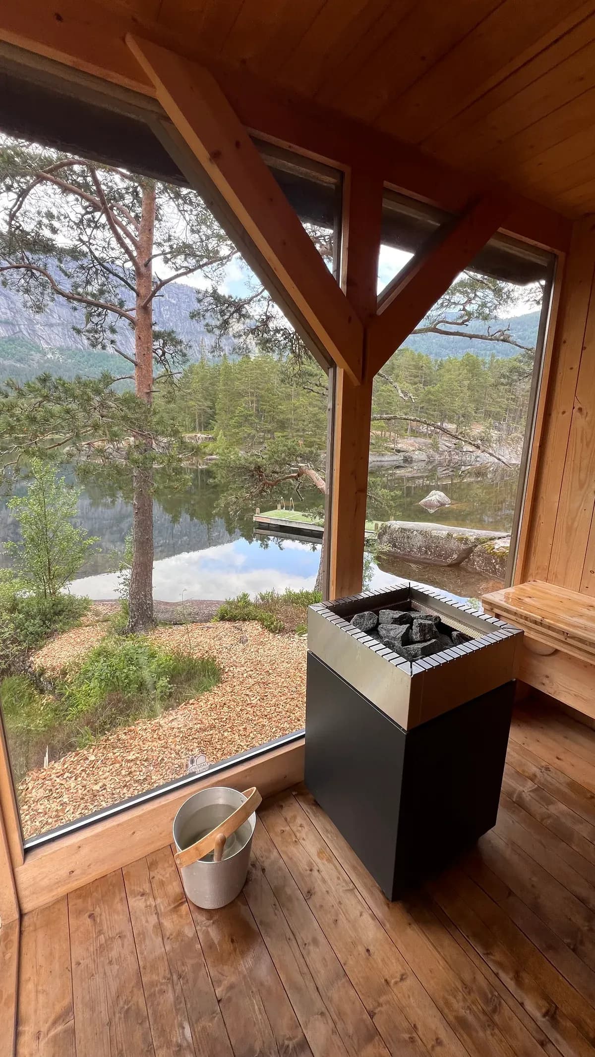 Interiør av SetesdalBox Sauna i Valle med badstueovn og panoramavinduer mot Otra