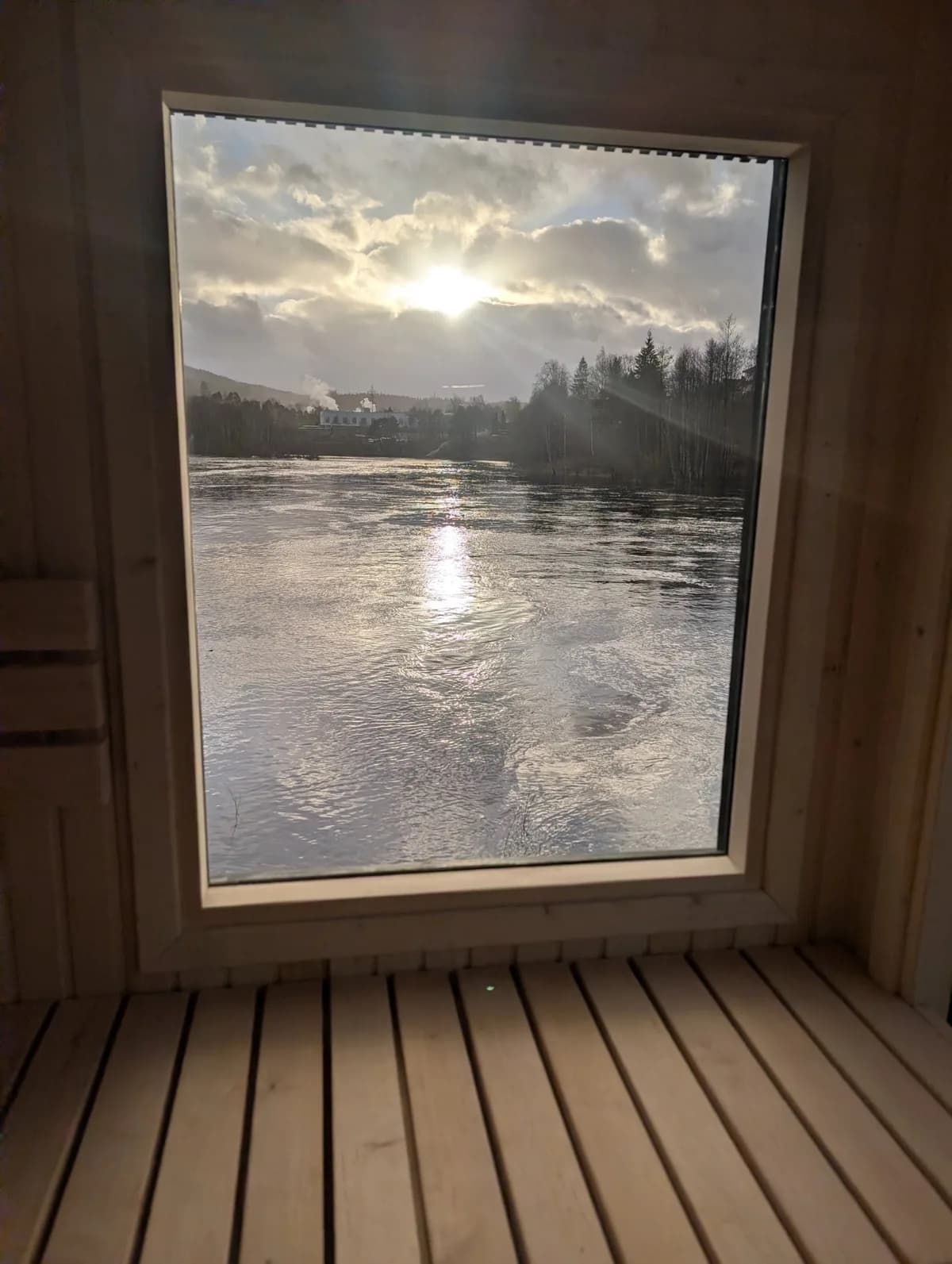 Elveutsikt fra SydSauna i Vennesla Utsikt fra SydSauna i Vennesla med solnedgang over elven gjennom panoramavindu