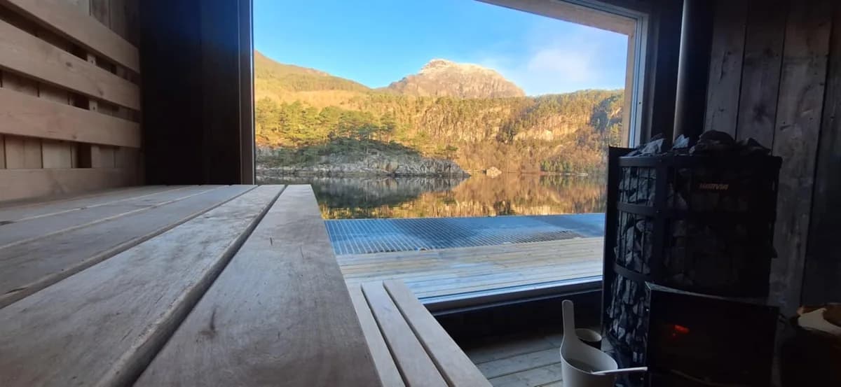 Interiør i Rybad badstue i Vikedal med utsikt mot fjord og fjell gjennom panoramavindu