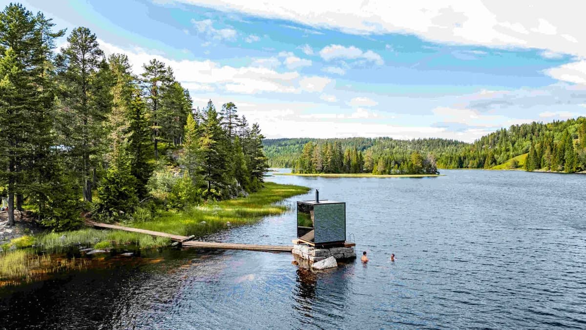 Badstova ved Spegle i Vinje med spegleveggar ved vatnet Hylen, omgitt av grøn natur